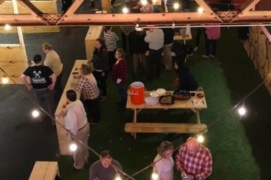 a group of people standing around at splitting edge axe throwing - pottstown